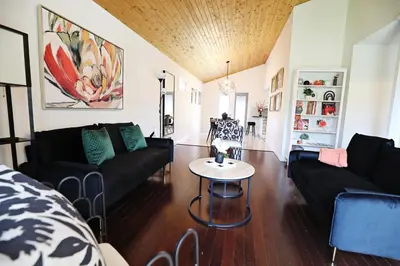 a living room with black couches and a table at Family Pet Friendly AC Disney Near WEM in Edmonton