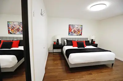 a bedroom with two beds with red and black pillows at Family Pet Friendly AC Disney Near WEM in Edmonton