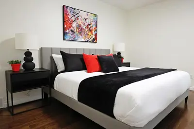 a bedroom with a large white bed with red pillows at Family Pet Friendly AC Disney Near WEM in Edmonton