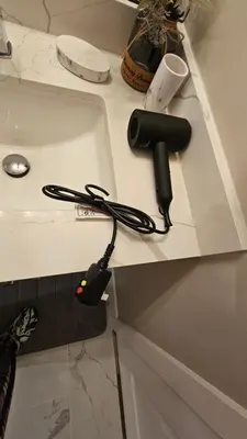 a hair dryer on a counter next to a sink at Luxury Basement Suite with 2 Bedrooms, 2 Queen Beds, Free Wi-Fi, and Free Parking in Calgary