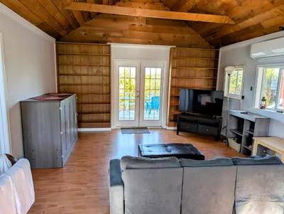a living room with a couch and a tv at Cliff Haven on the Bay in Alert Bay