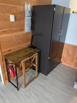 a wooden table next to a refrigerator in a room at Gordie's Inn & Suites in Alert Bay