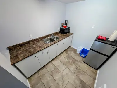 a kitchen with a sink and a refrigerator at Gordie's Inn & Suites in Alert Bay
