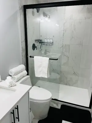 a bathroom with a toilet and a glass shower at Amy's 2-Bedroom Residence in Calgary