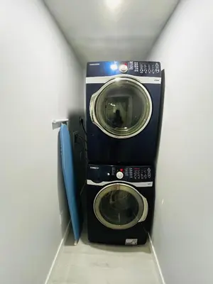 a washer and dryer in a corner of a room at Amy's 2-Bedroom Residence in Calgary