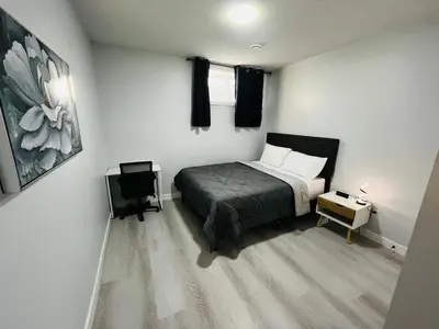 a bedroom with a bed and a table and a chair at Amy's 2-Bedroom Residence in Calgary