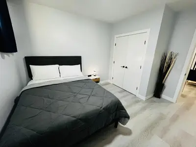 a bedroom with a black bed and a white door at Amy's 2-Bedroom Residence in Calgary