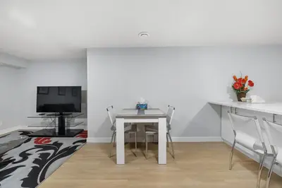 a dining room with a white table and a tv at Flora's House in Calgary