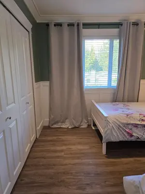 a bedroom with a bed and a window at Cozy home in Brookswood in Langley
