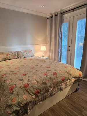 a bedroom with a bed with a floral bedspread at Cozy home in Brookswood in Langley