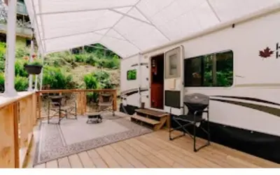 an outside view of an rv with a deck with chairs at Lower Meadow on Saltspring Island in Fernwood