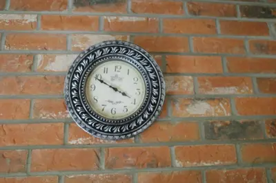 a clock is hanging on a brick wall at Capilano Happylife in North Vancouver