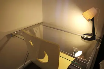 a glass table with a lamp and a chair at Capilano Happylife in North Vancouver