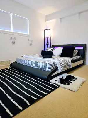 a bedroom with a bed with a black and white rug at Comfy Stylish Room in the Heart of Vancouver- Private Parking, Self Check-in & just 4 mins to Metrotown! in Vancouver