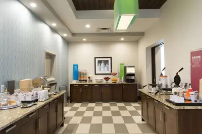 a large kitchen with wooden cabinets and a checkered floor at Hampton Inn by Hilton Lloydminster in Lloydminster
