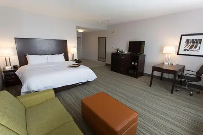a hotel room with a bed and a chair and a desk at Hampton Inn by Hilton Lloydminster in Lloydminster