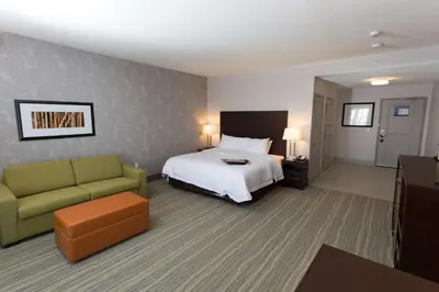 a hotel room with a bed and a couch at Hampton Inn by Hilton Lloydminster in Lloydminster