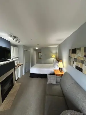 a living room with a bed and a couch in a room at Borgata Lodge Resort in Kelowna