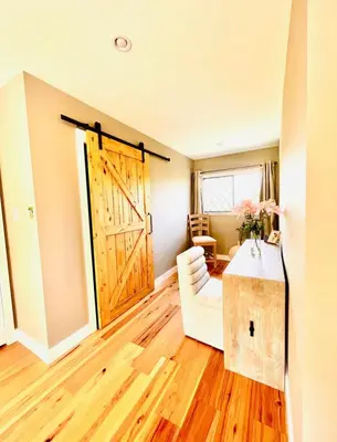 a living room with a large wooden door and a couch at Oceanside Manor - Fancy Room - Golf course & Beach View in Qualicum Beach