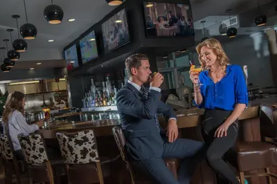 a man and a woman eating at a bar at Hotel Clique Calgary Airport in Calgary