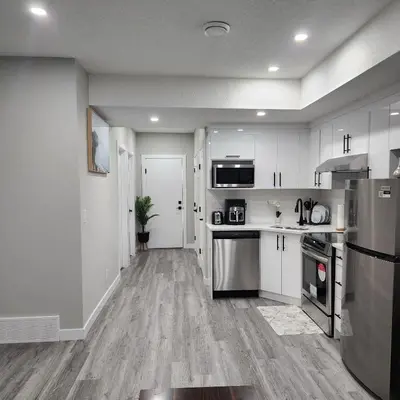 a kitchen with white cabinets and stainless steel appliances at fabulous and cozy guest suite in Calgary