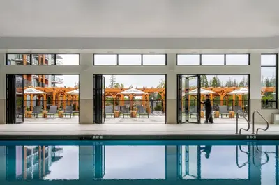a person standing next to a swimming pool at Naturally Pacific Resort in Campbell River