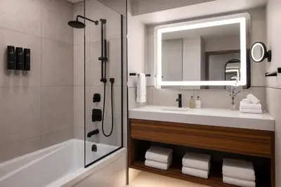 a bathroom with a tub and a sink and a mirror at Naturally Pacific Resort in Campbell River