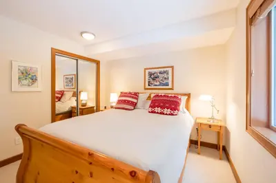 a bedroom with a large bed with red pillows at #24 Treeline in Whistler