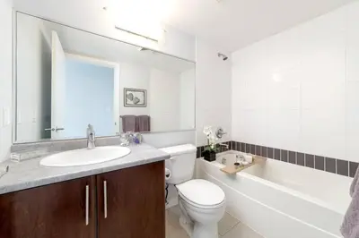 a bathroom with a sink and a toilet and a tub at Modern spacious Apt plus Solarium and Den in Downtown Vancouver with Parking and Pool in Vancouver