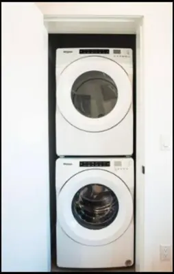 a washer and dryer in a white room at Base Camp Revy! in Revelstoke