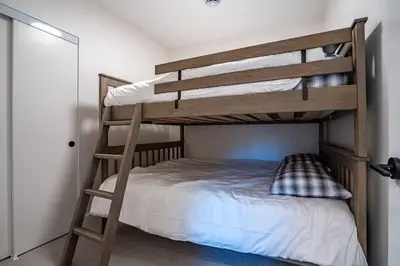 a bedroom with a bunk bed with a ladder at Base Camp Revy! in Revelstoke