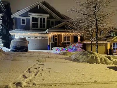 a house with a lot of snow in front of it at 安静社区主楼层豪华主卧套房&独立浴室浴缸 in Coquitlam