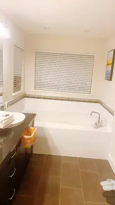 a white bathroom with a tub and a sink at 安静社区主楼层豪华主卧套房&独立浴室浴缸 in Coquitlam