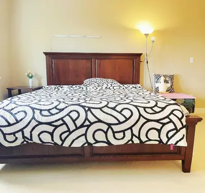 a bedroom with a bed with a black and white comforter at 安静社区主楼层豪华主卧套房&独立浴室浴缸 in Coquitlam