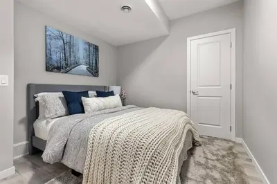 a bedroom with a bed with a blanket on it at Brand New Luxury Walk-out Suite - Calgary in Calgary