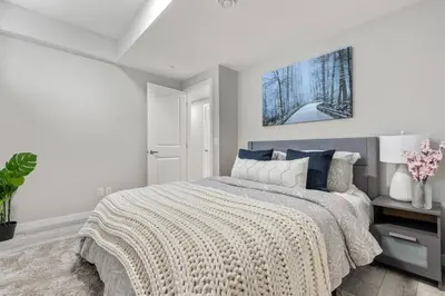 a white bedroom with a bed with a blanket at Brand New Luxury Walk-out Suite - Calgary in Calgary
