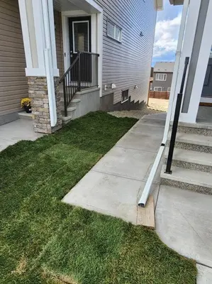 a house with a porch and a stairway leading to a door at Brand New Luxury Walk-out Suite - Calgary in Calgary