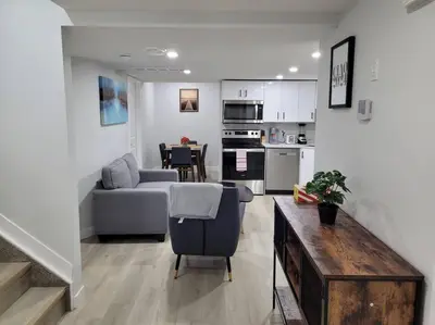 a living room and kitchen with a couch and a table at Beautiful Comfy Guest Suite in West EDM in Edmonton