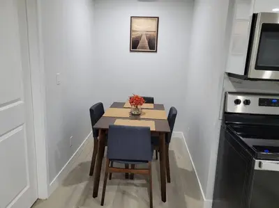a kitchen with a table with chairs and a microwave at Beautiful Comfy Guest Suite in West EDM in Edmonton