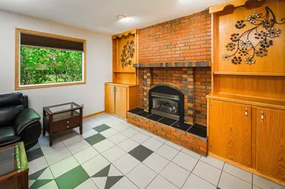 a living room with a brick fireplace and a couch at Nice 3 Bedroom 2 Bathroom Home Fenced yard near Downtown and YYC in Calgary