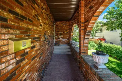 a brick wall with a walkway in a house at Nice 3 Bedroom 2 Bathroom Home Fenced yard near Downtown and YYC in Calgary
