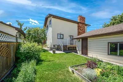 a backyard of a house with a fence at Nice 3 Bedroom 2 Bathroom Home Fenced yard near Downtown and YYC in Calgary