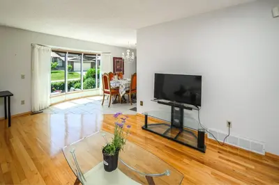a living room with a flat screen tv and a table at Nice 3 Bedroom 2 Bathroom Home Fenced yard near Downtown and YYC in Calgary