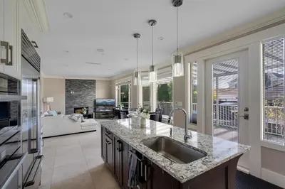 a kitchen with a sink and a living room at Luxurious Multi-Family Home in Vancouver West, 10 Mins Downtown in Vancouver
