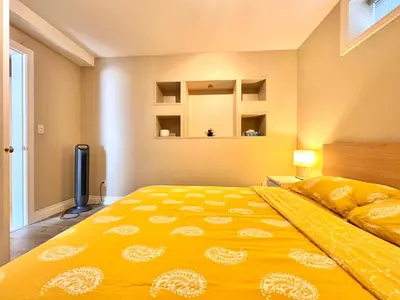 a large yellow bed in a room with a window at Cozy 1bedroom Suite in Vancouver Westside in Vancouver
