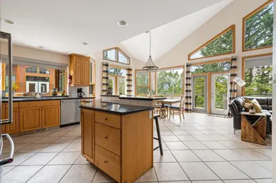 an open kitchen with wooden cabinets and windows at Chateau Lawrence, Pool Table, Kids' Gaming Room in Fairmont Hot Springs