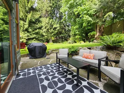 a patio with a couch and a table on a patio at 2BD Guest Suite Sleeps 6 Near Downtown & Beach in West Vancouver