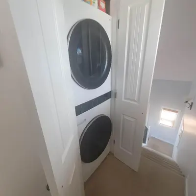a washer and dryer in a room with a door at La Casa Lakeside Resort - Amazing Panoramic View Lakeside House with Pools, Hot Tubs & More! in Kelowna
