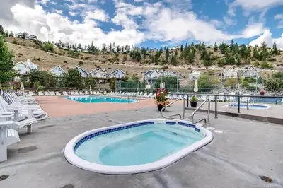 a large pool with a hot tub on a patio at La Casa Lakeside Resort - Amazing Panoramic View Lakeside House with Pools, Hot Tubs & More! in Kelowna
