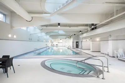 a large swimming pool in a building at The Altitude with Mountain & City Views, Pool & Hot Tub in Vancouver